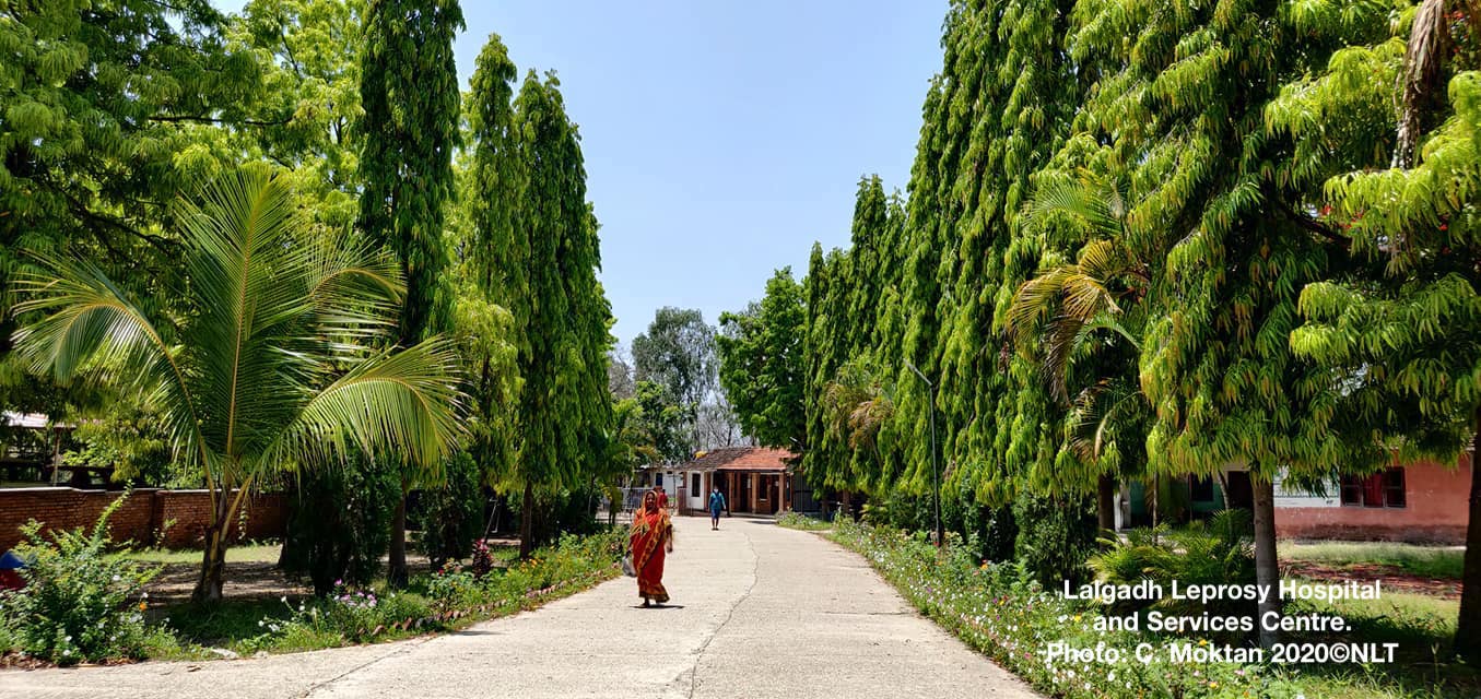 Two people walking on drive leading to Lalgadh Leprosy Hosiptal and Services Centre.